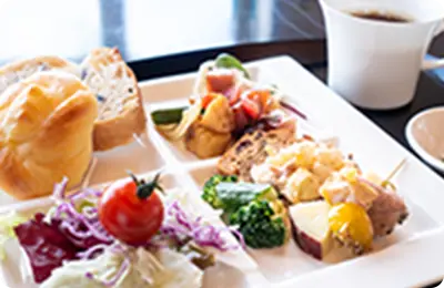 白いプレートに盛り付けられた彩り豊かなランチプレートとコーヒー。